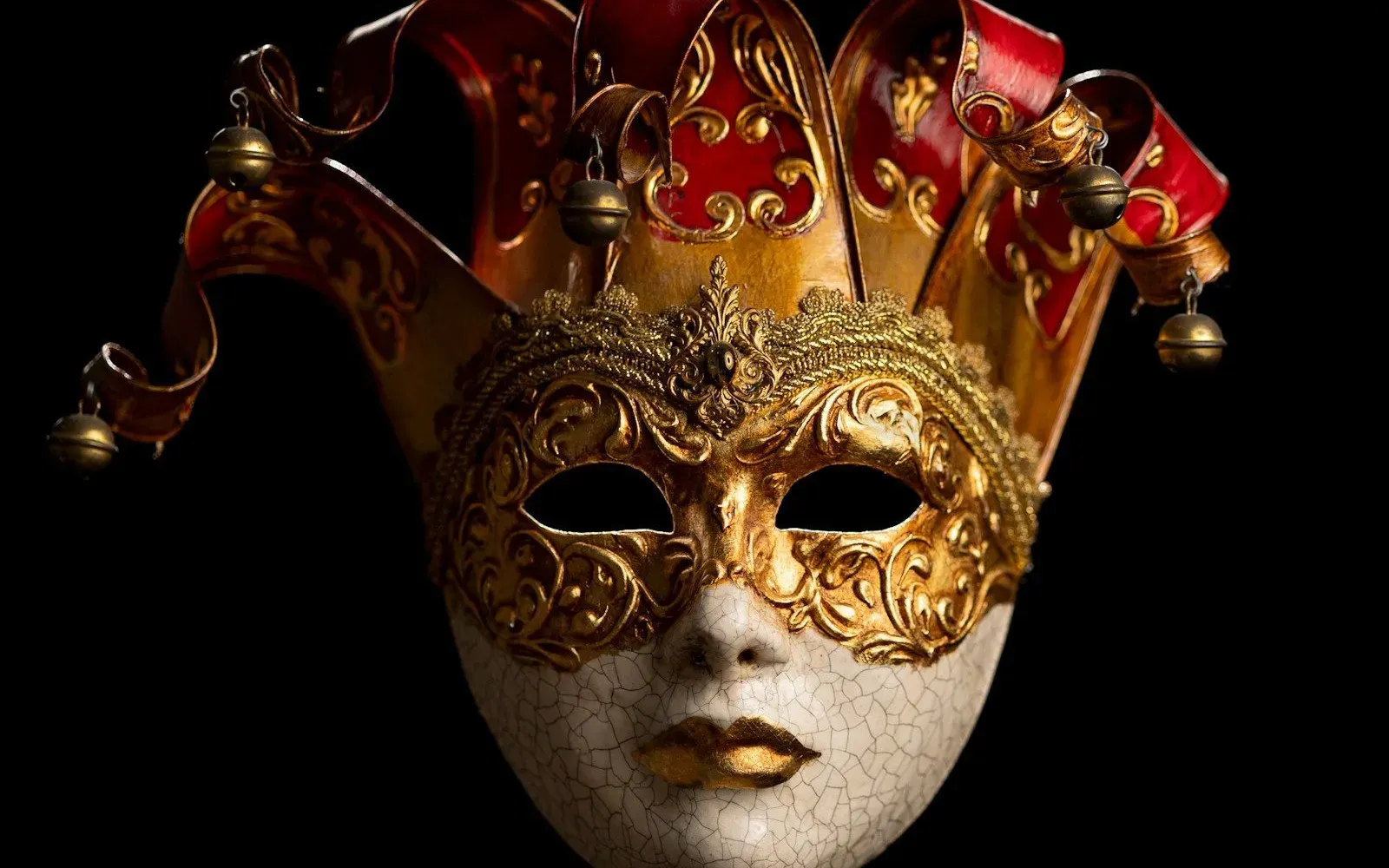 Goldene venezianische Maske mit Narrenkappe vor schwarzem Hintergrund – Hellovy Erfahrungen